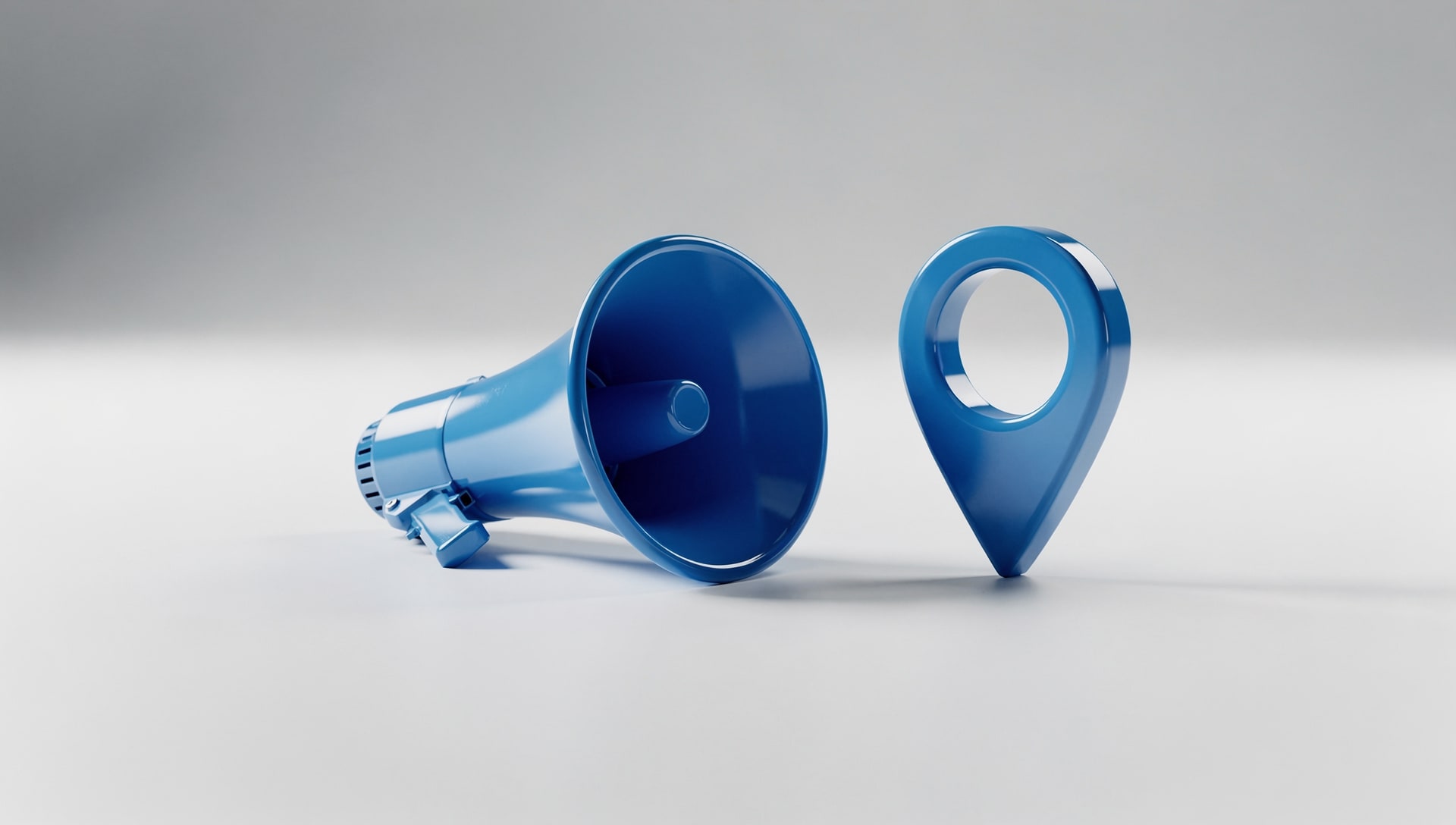Blue megaphone lying beside a blue map pin on a clean studio surface